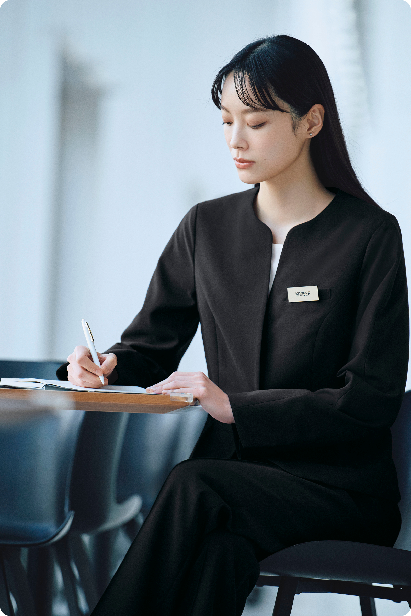 ENJOY Noirの黒色のスーツで書き物をする女性プランナー