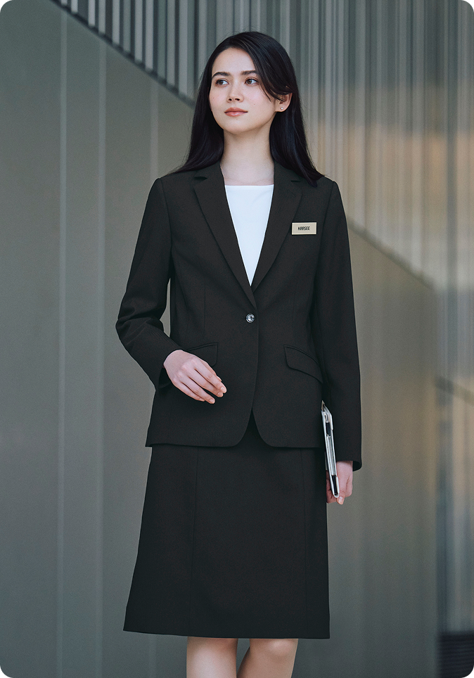 ENJOY Noirの黒色の制服を着用し、笑顔で立っている2名の女性レセプションスタッフ